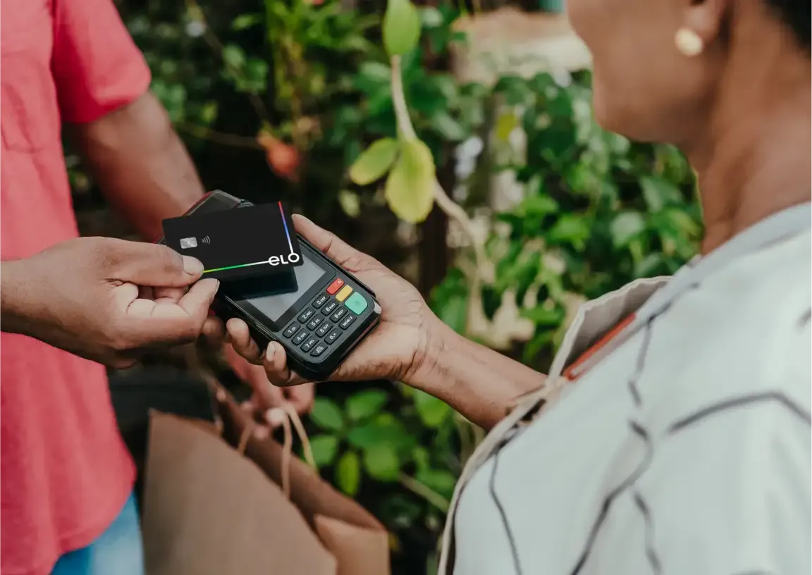 Homem com jaqueta amarela e branca segurando um cartão