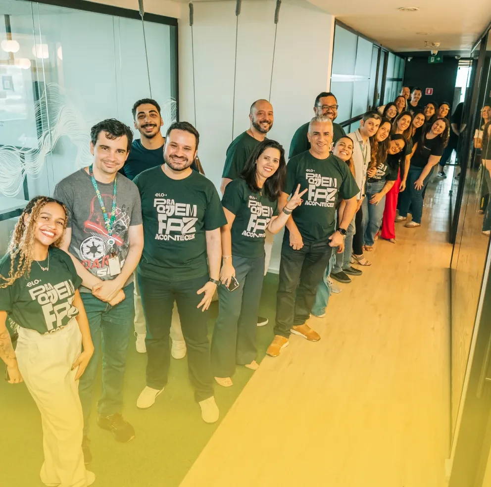 Imagem de vários funcionários fazendo pose para foto no corredor do escritóirio