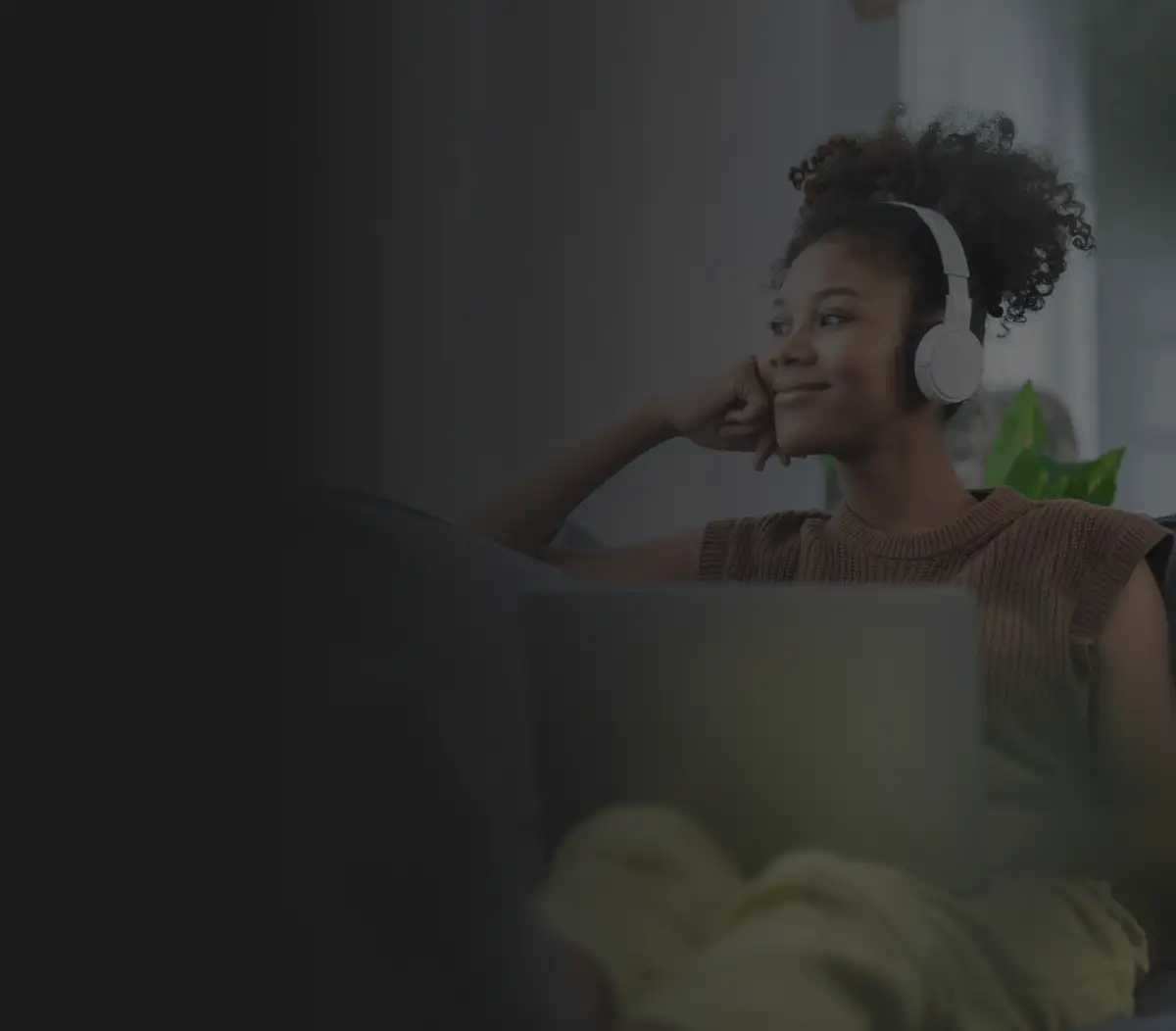 Mulher negra sorrindo com fone de ouvido ouvindo música