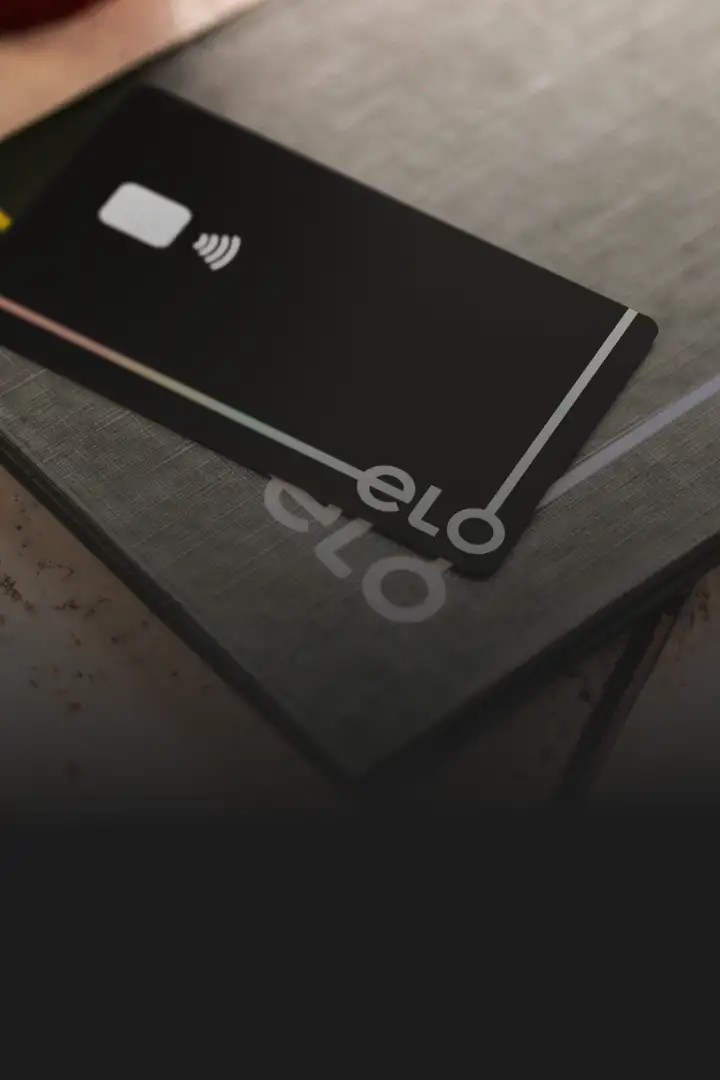 Mulher sorrindo com cartão elo na mão